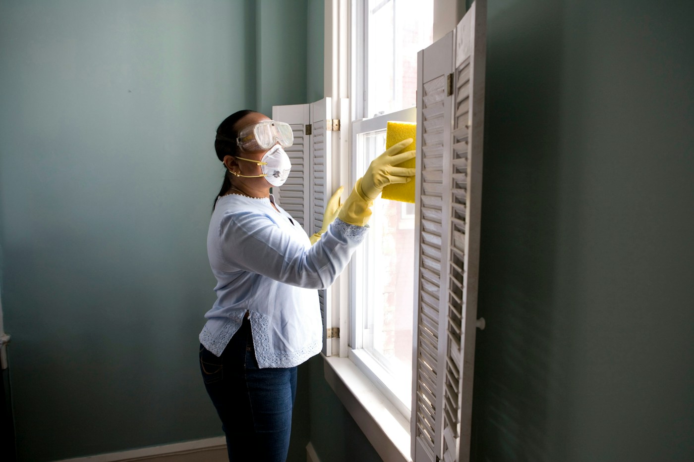A cleaning professional working on a customer's window